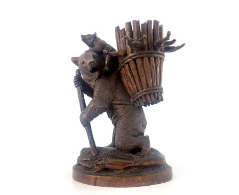 A Black Forest decanter stand, late 19th/early 20th Century, carved as a bear with staff and cub with an open basket and bran