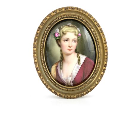 A European oval convex porcelain plaque, late 19th Century, in the manner of KPM, painted with a portrait of a young lady, bu