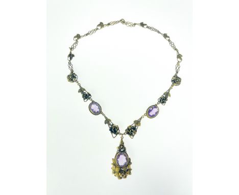 An Arts and Crafts silver gilt and amethyst necklace, the central drop pendant with oval stone in ropetwist border above flor