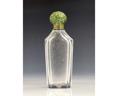 An enamelled yellow metal mounted cut glass scent bottle, the champleve hinged lid of foliate scroll design in green guilloch