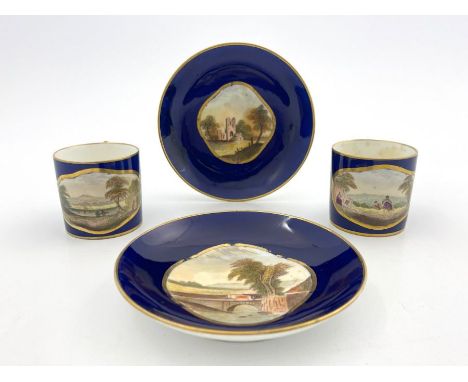 A pair of Derby Bloor coffee cans and saucers, circa 1830, each painted with a vignette landscape view in a gilt quatrefoil b