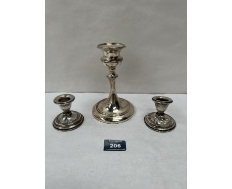 A George V silver loaded candlestick, Chester 1921, 5¾' high; together with a pair of silver loaded squat candlesticks (A.F.)