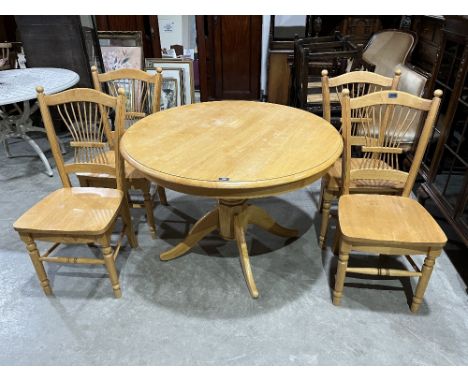 A light wood round dining table, 41' diam; with a set of four chairs