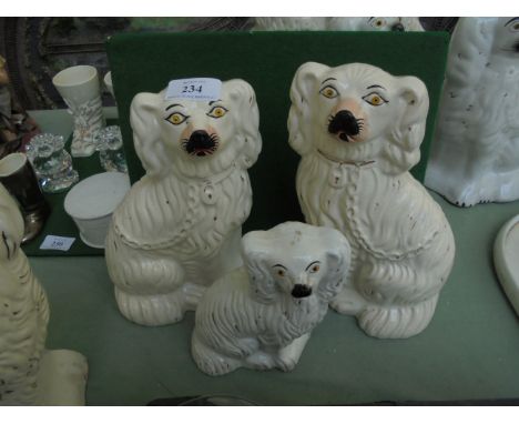 Pair of cream painted Spaniel mantelpiece ornaments and another smaller of a puppy at foot