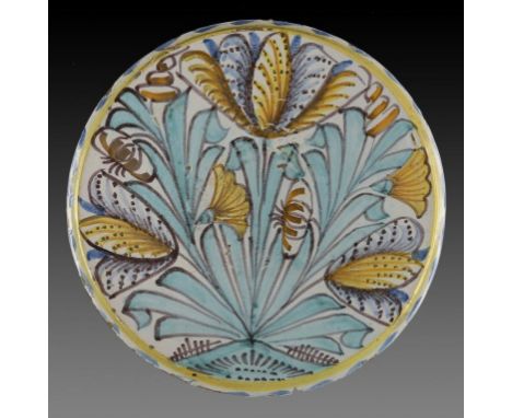 AN ENGLISH DELFTWARE BLUE DASH TULIP CHARGER, C1670-85  painted with tulips, lilies and carnations, the back with small circu