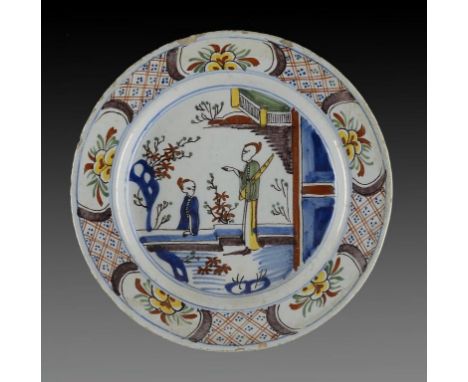 A DUTCH DELFTWARE POLYCHROME DISH,   18TH C  painted with two Chinese figures and diaper border, 30cm diam ++Chip on rim at 1