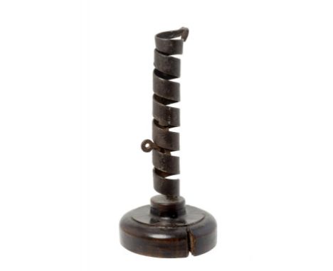 A WROUGHT IRON SPIRAL CANDLESTICK, 18TH C   with ejector, on turned wood foot, 22cm h ++Rust pitted foot chipped but complete