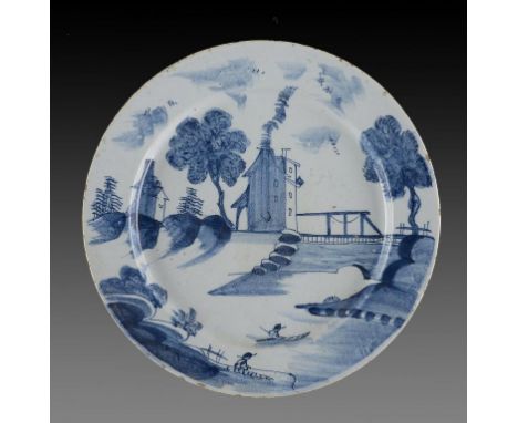 A DELFTWARE DISH, PROBABLY BRISTOL, C1750-60  painted with a tall building with smoking chimney and river scene with fisherma