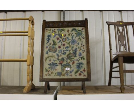 An oak framed and needlework firescreen 