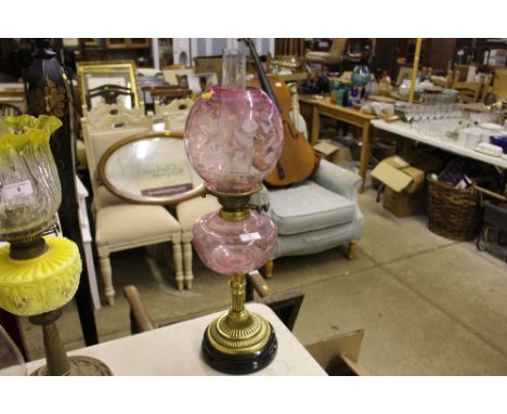 A pink glass and brass oil lamp with etched glass shade and font 