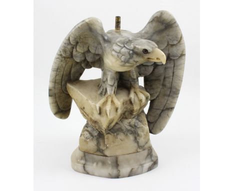 A marble-effect figure of a hunting eagle with partially outspread wings, on a stylised rocky plinth base, height 27cm. CONDI