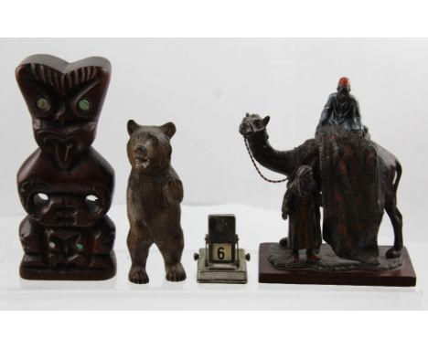 A small group of collectibles to include a perpetual date calendar, a Native American totem, an Orientalist hand-painted spel