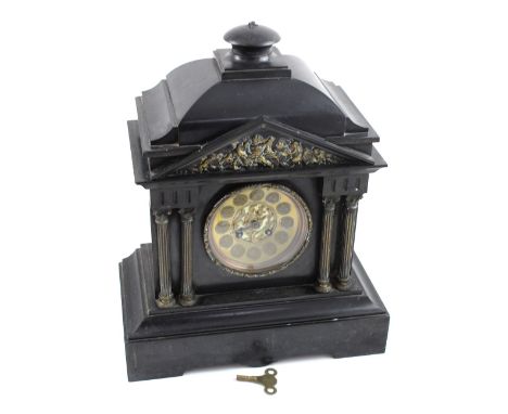 An architectural black slate mantel clock with brass frieze to the pediment supported on two pairs of Corinthian columns, on 