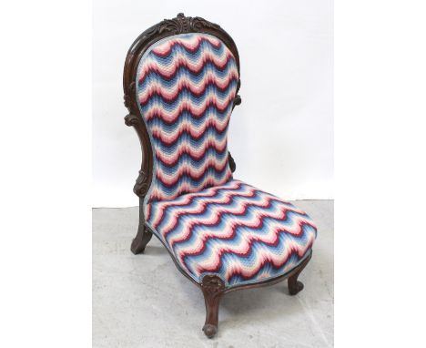 A Victorian walnut spoon-back fireside chair with acanthus carved cartouche, supported on carved cabriole legs to scroll feet