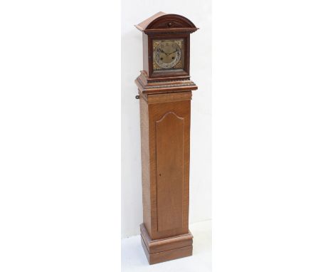 A 1930s oak bracket clock striking on twin coiled rods, mounted on a later oak plinth, creating the appearance of a short lon