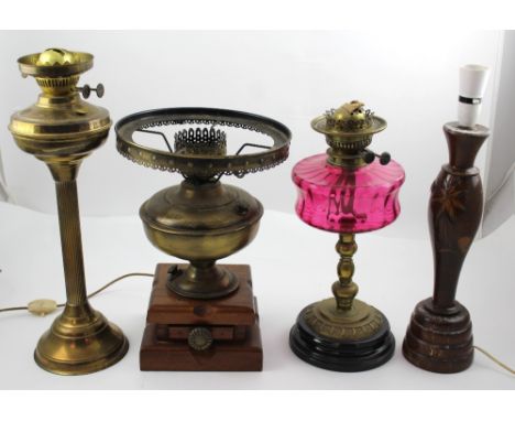 Three vintage paraffin lamps to include a large brass example with reeded column, height 48.5cm, a brass example with cranber