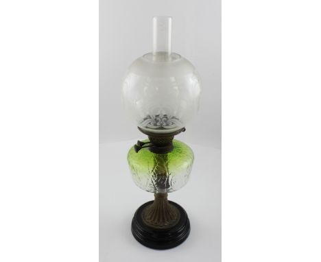 A vintage oil lamp with green glass reserve with spider web design, clear and opaque glass shade to a marbled stepped base, h