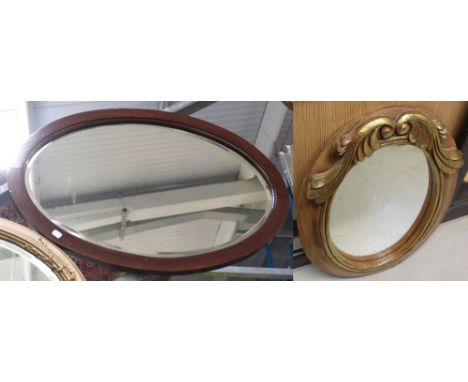 A vintage mahogany-framed oval bevel-edged wall mirror, length 80cm and an oval decorative wood-framed mirror with gilded lea
