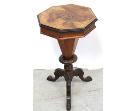 A Victorian octagonal walnut sewing table with marquetry top to octagonal column base on outswept tripartite support, contain