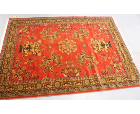 A red ground floral Keshan carpet with stylised multi-border in greens and browns, 303 x 221cm.