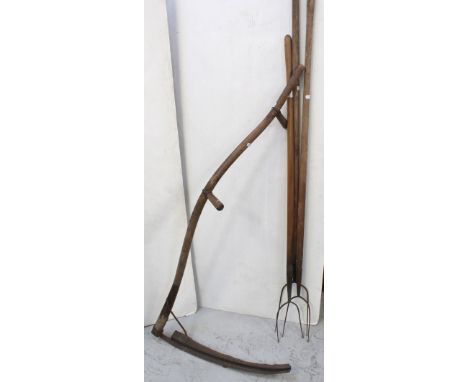 A collection of vintage hand tools to include three pitchforks, length of each approx 75cm and a scythe (4).