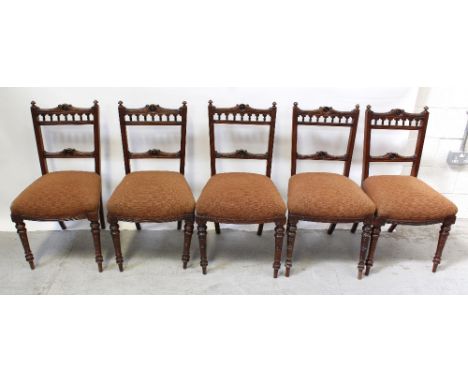 A set of five Edwardian walnut dining chairs with bobbin-turned gallery backs, on turned front legs with stuff-over seats, he