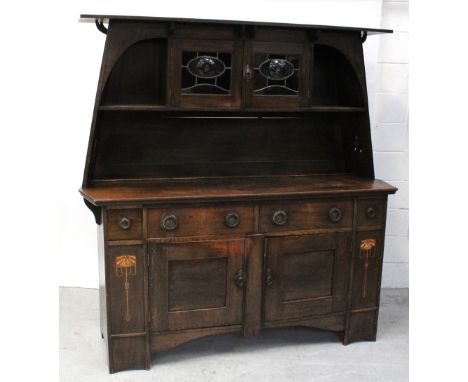 A good late 19th century Arts and Crafts sideboard with twin bull's-eye leaded cupboard doors, plate rack top over two-drawer