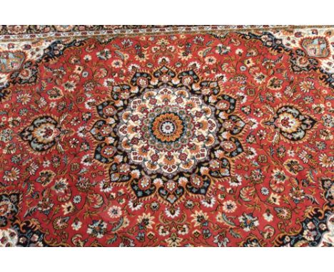 A russet ground machine-knotted Tabriz carpet, 195 x 290cm.