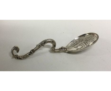 A heavy cast silver sifter spoon with scroll handle. Approx. 51 grams. Est. £100 - £150.