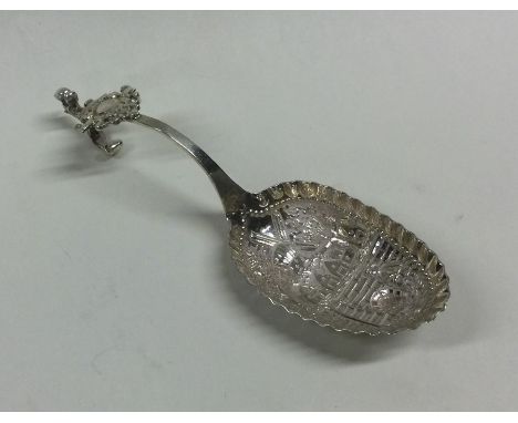 A Dutch silver caddy scoop decorated with figures. Bearing import marks for Sheffield. Approx. 34 grams. Est. £25 - £35.