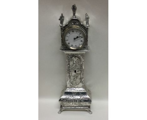 A large 19th Century Dutch silver model of a grandfather clock profusely decorated with winged infants and white enamelled di