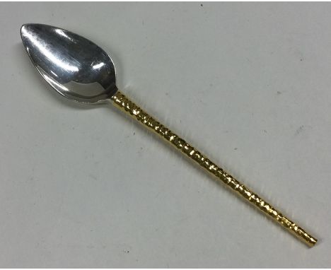 STUART DEVLIN: A tapering silver and silver gilt spoon. Approx. 23 grams. Est. £40 - £60.