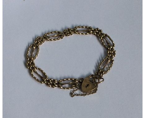 A 9 carat fancy link gate bracelet with heart shaped padlock. Approx. 8 grams. Est. £100 - £150.
