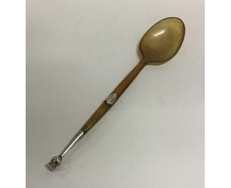 A horn and silver mounted spoon in the form of a thistle. Approx. 12 grams. Est. £10 - £20.