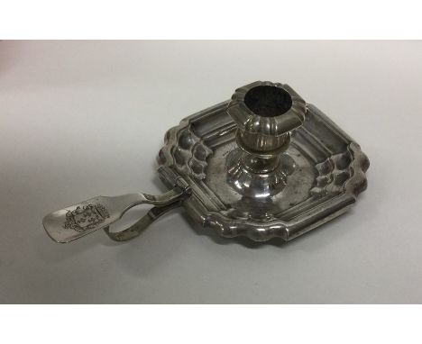 A Continental Antique silver candlestick of shaped form with crested thumb piece. Approx. 93 grams. Est. £70 - £80.