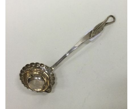A small 18th Century silver cream ladle with leaf handle. Approx. 10 grams. Est. £15 - £20.