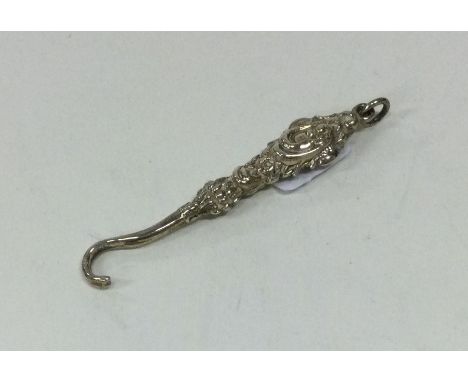 A miniature silver embossed button hook with loop top. Approx. 3 grams. Est. £10 - £20.