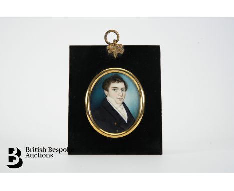 Jacques James (b.1803-    ) portrait miniature, oval watercolour, circa 1824, of a young gentleman in a navy blue coat, appro