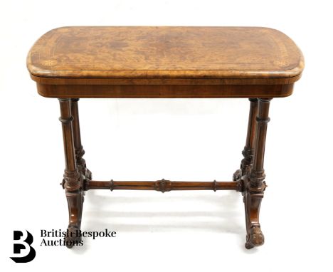 A Victorian burr walnut card table, swivel top with green baize interior, over carved supports and stretcher, with decorative