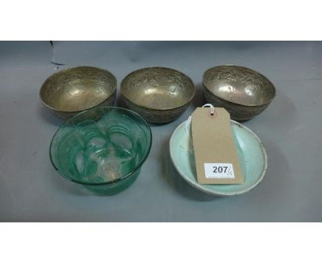 Three white metal bowls, embossed with scrolling foliate decoration, together with a green blown glass bowl with rippled deco