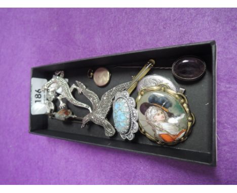A small selection of white metal jewellery including HM silver locket, amethyst stick pin, marcasitte brooches, enamelled bar
