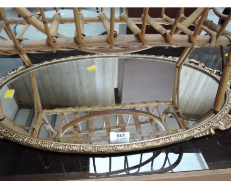A vintage oval hall mirror with metal regency style frame