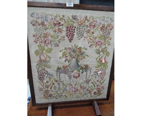 A vintage fire screen with embroidery panel