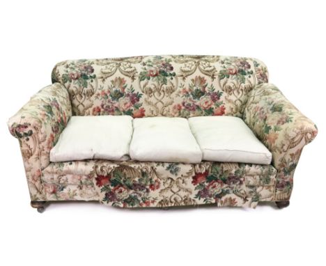 An early 20th century settee, with drop end, upholstered in floral tapestry, on bun feet and castors, 177cm wide x 97cm deep 