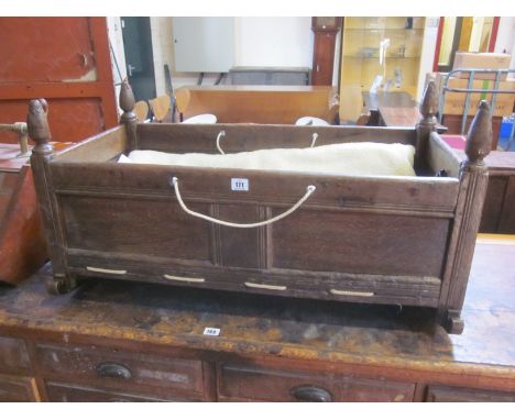 An oak panelled cradle 86cm wide and fire tools 