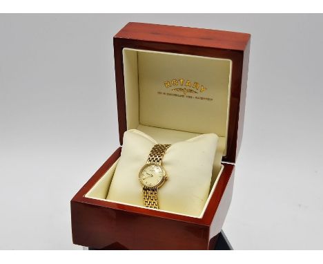 A boxed Rotary ladies watch with baton numerals and yellow metal strap.