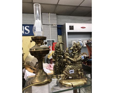 PAIR OF BRASS PUNCH AND JUDY DOORSTOPS AND AN ELECTRIFIED OIL LAMP
