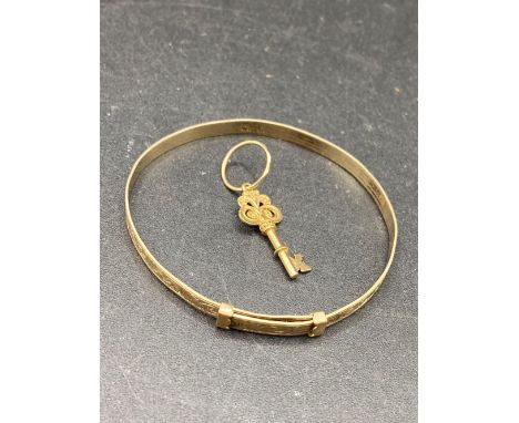 A 9ct key charm pendant together with a 9ct metal core bangle