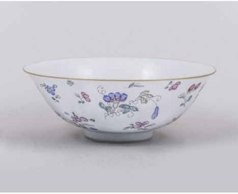 A Chinese polychrome bowl, bearing Qianlong six character seal mark, decorated with dispersed floral sprigs in famille rose e