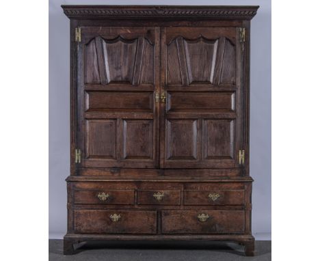 A Joined oak press cupboard, in part 18th century with adaptations, moulded dog tooth pediment, two panel doors to the upper 